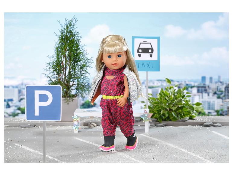 Panenka BABY born v červené kombinéze a stříbrné vestě, s dopravními značkami parkování a taxi.