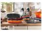 Tři pánve Le Creuset naskládané v kuchyni.