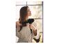 Žena si suší vlasy fénem a kulatým kartáčem.