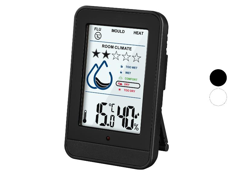 Černý digitální teploměr a vlhkoměr s displejem zobrazujícím klima v místnosti.