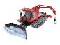 Červený sněžný rolba PistenBully 600 s radlicí a zvedacím ramenem.