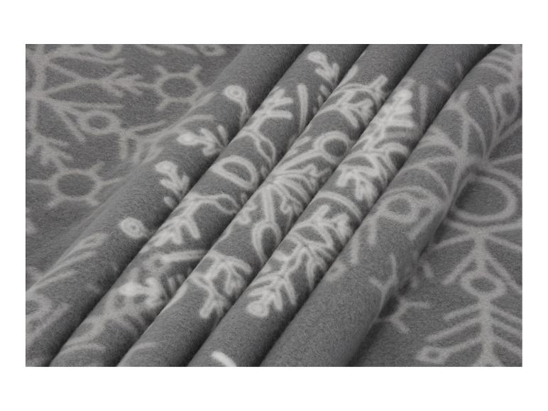 Šedá fleecová deka s bílými vzory sněhových vloček.