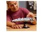 Žena sestavuje model LEGO Star Wars Home One Star Cruiser na stojanu.