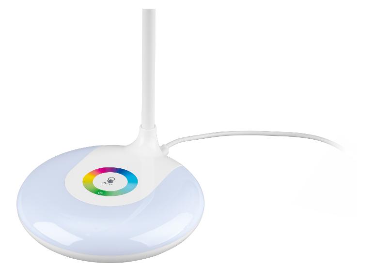 Bílá stolní lampa s osvětlenou kulatou základnou a barevným kruhem.