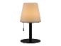 Moderní stolní lampa se smetanovým stínidlem a černou základnou.