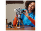 Osoba staví LEGO filmovou kameru Mickey Mouse s filmovým pásem zobrazujícím ikonické postavy Disney.