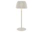 Bílá stojací lampa s plisovaným stínidlem, vyzařující teplé světlo.
