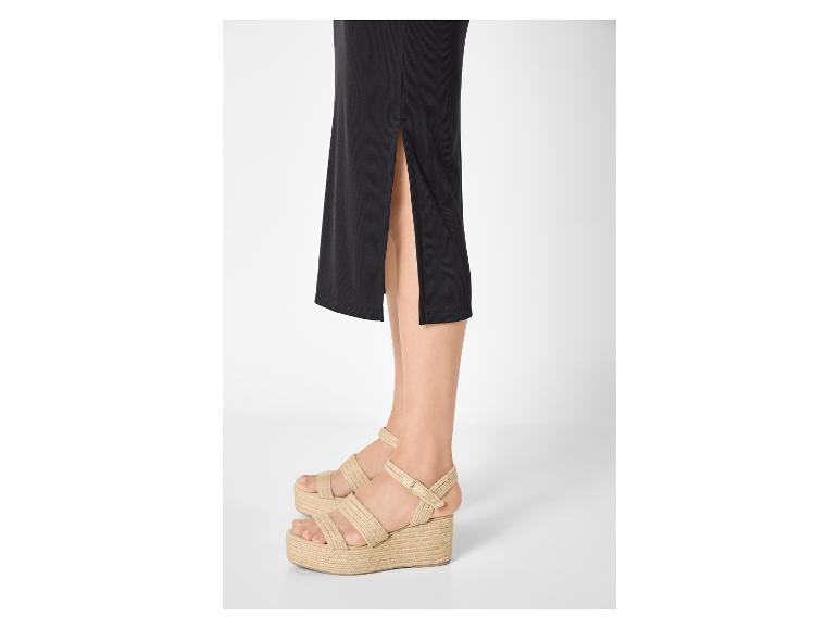 Žena v černé sukni a espadrilových sandálech na platformě