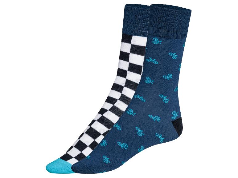 Dva páry ponožek, jeden s černobílým kostkovaným vzorem a druhý s modrými koly.