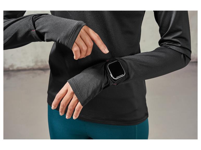 Žena má na sobě černý sportovní top a Apple Watch.