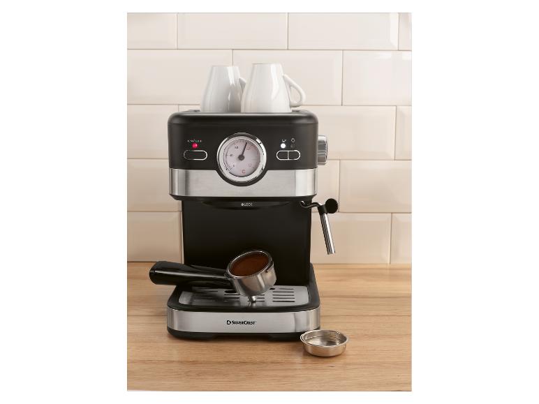 Espresso kávovar se dvěma šálky a portafiltrem s kávou na dřevěné desce.