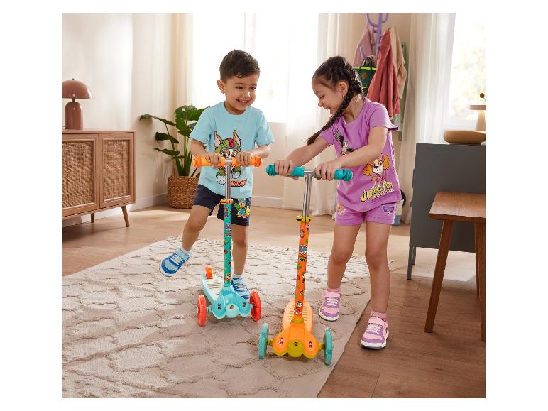 Dvě děti si hrají s barevnými koloběžkami Paw Patrol.
