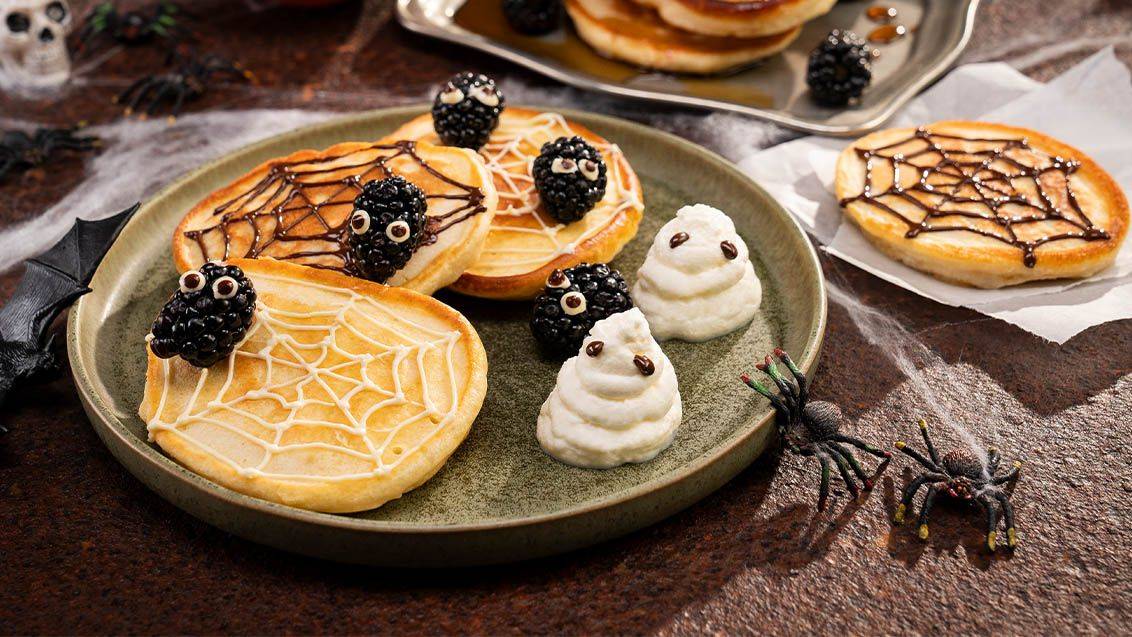 Halloweenské palačinky se vzory pavučin, ostružinovými pavouky a pusinkovými duchy.