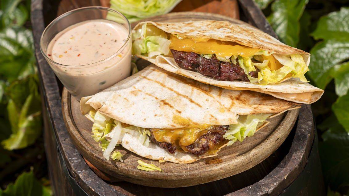 Quesadily s hovězím masem, sýrem a salátem, podávané se zálivkou.