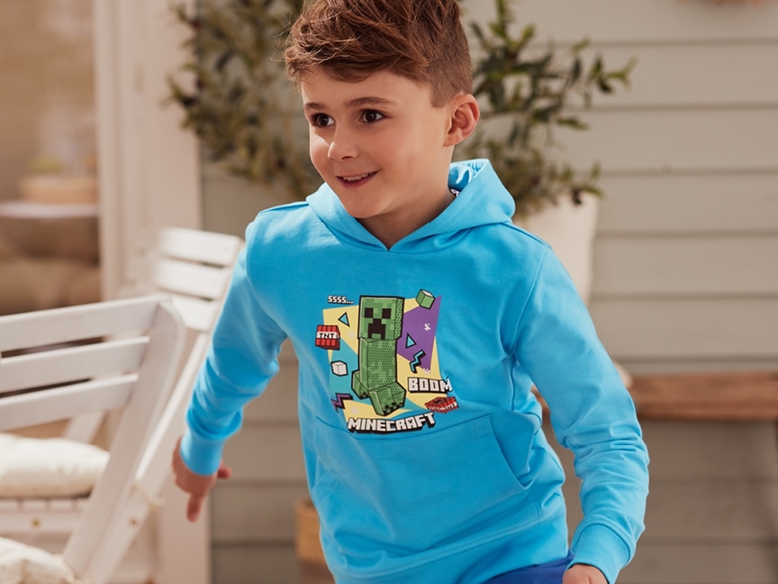 Chlapec v modré mikině s motivem Minecraftu.