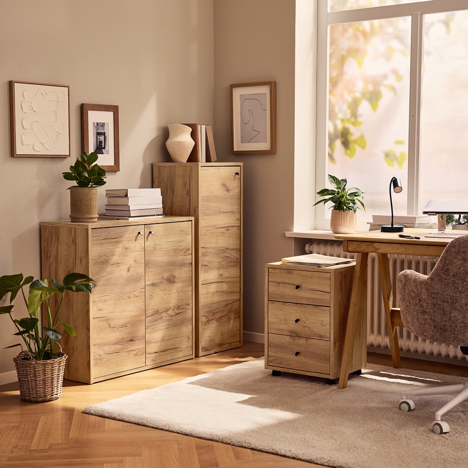 Dřevěné skříně a komody v domácí kanceláři s psacím stolem a rostlinami.
