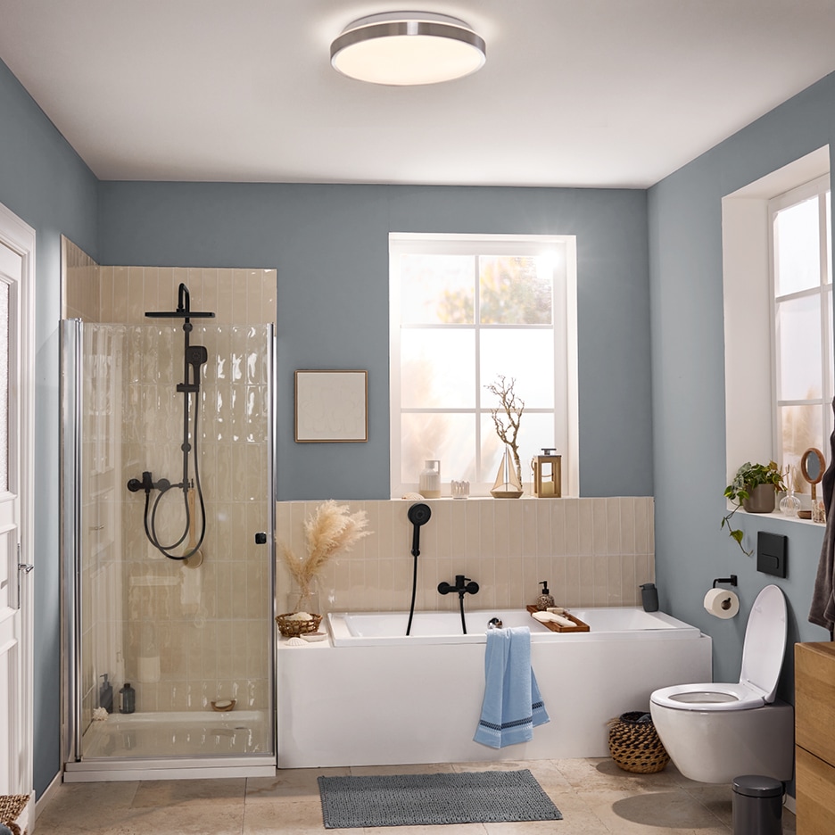 Moderní koupelna s vanou, sprchovým koutem, toaletou a stropním svítidlem.