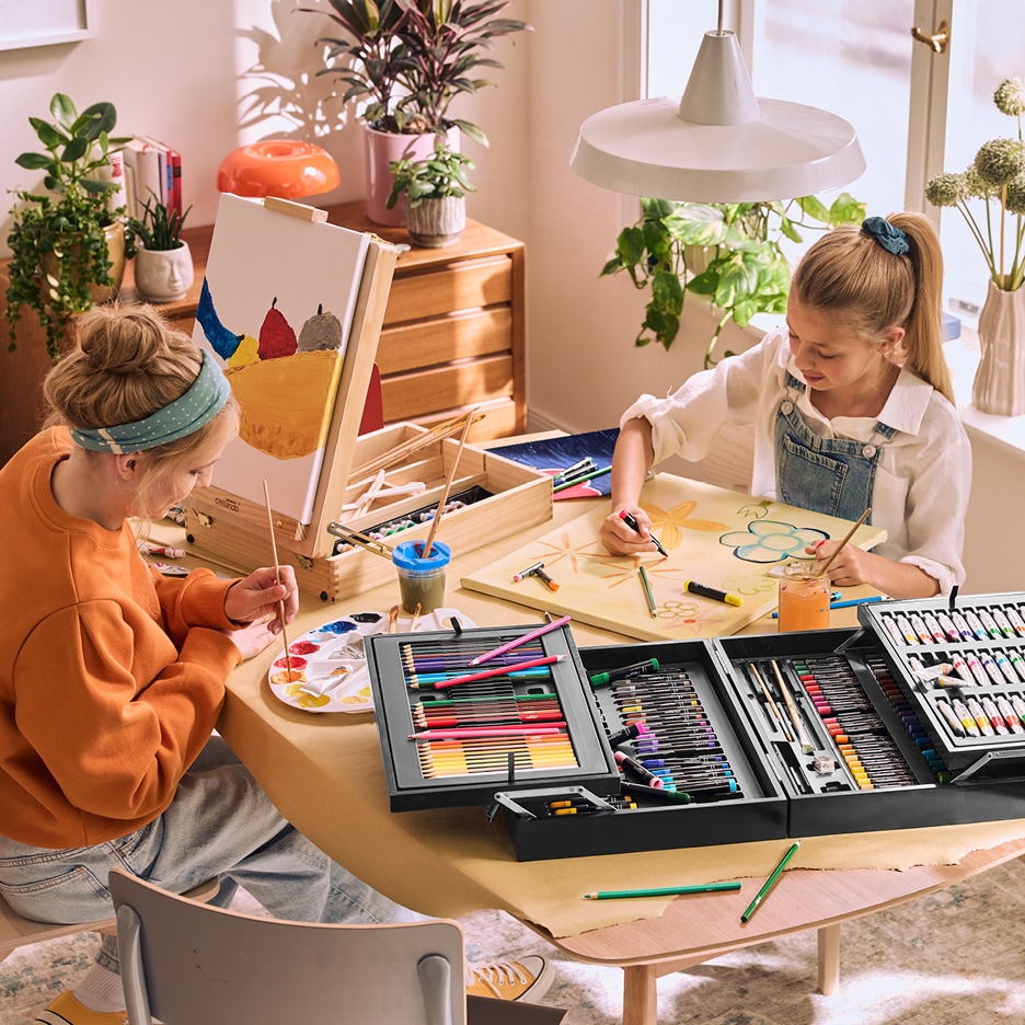 Dvě dívky malují s uměleckou sadou Crelando, jedna na plátno, druhá na papír.