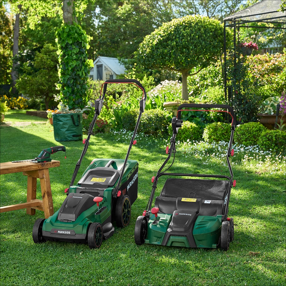 Dvě sekačky na trávu a nůžky na živý plot v zelené zahradě.