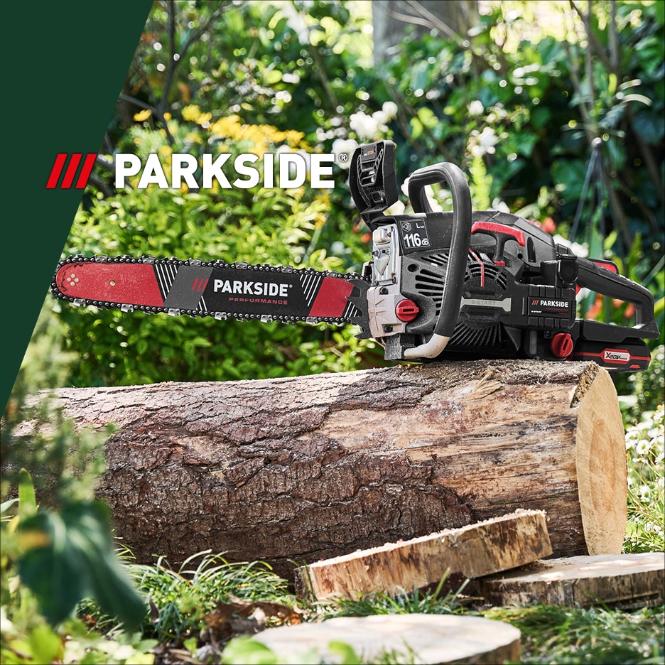 Motorová pila na dřevěném kmeni v zahradě.