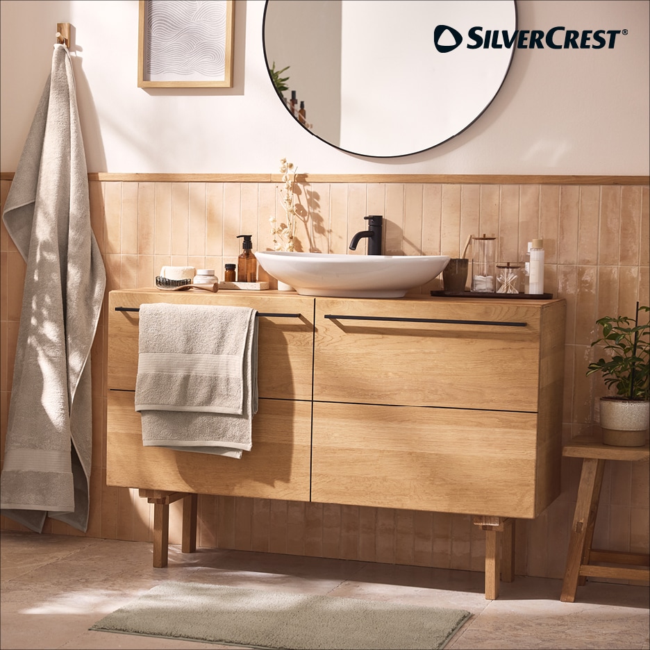 Koupelnová skříňka s umyvadlem, zrcadlem a ručníky v přírodním stylu.