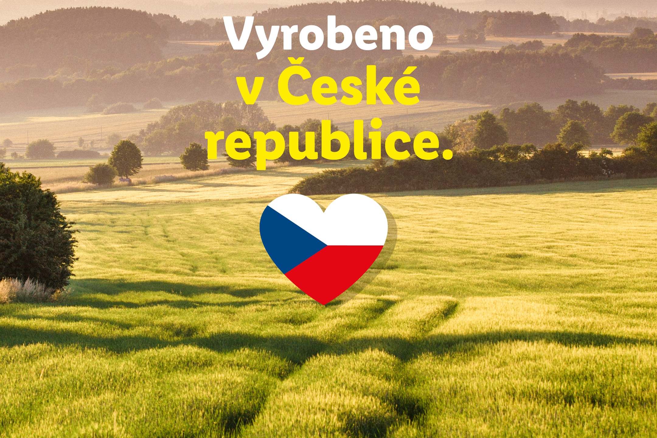 Zelená krajina s textem 'Vyrobeno v České republice' a srdcem s českou vlajkou.