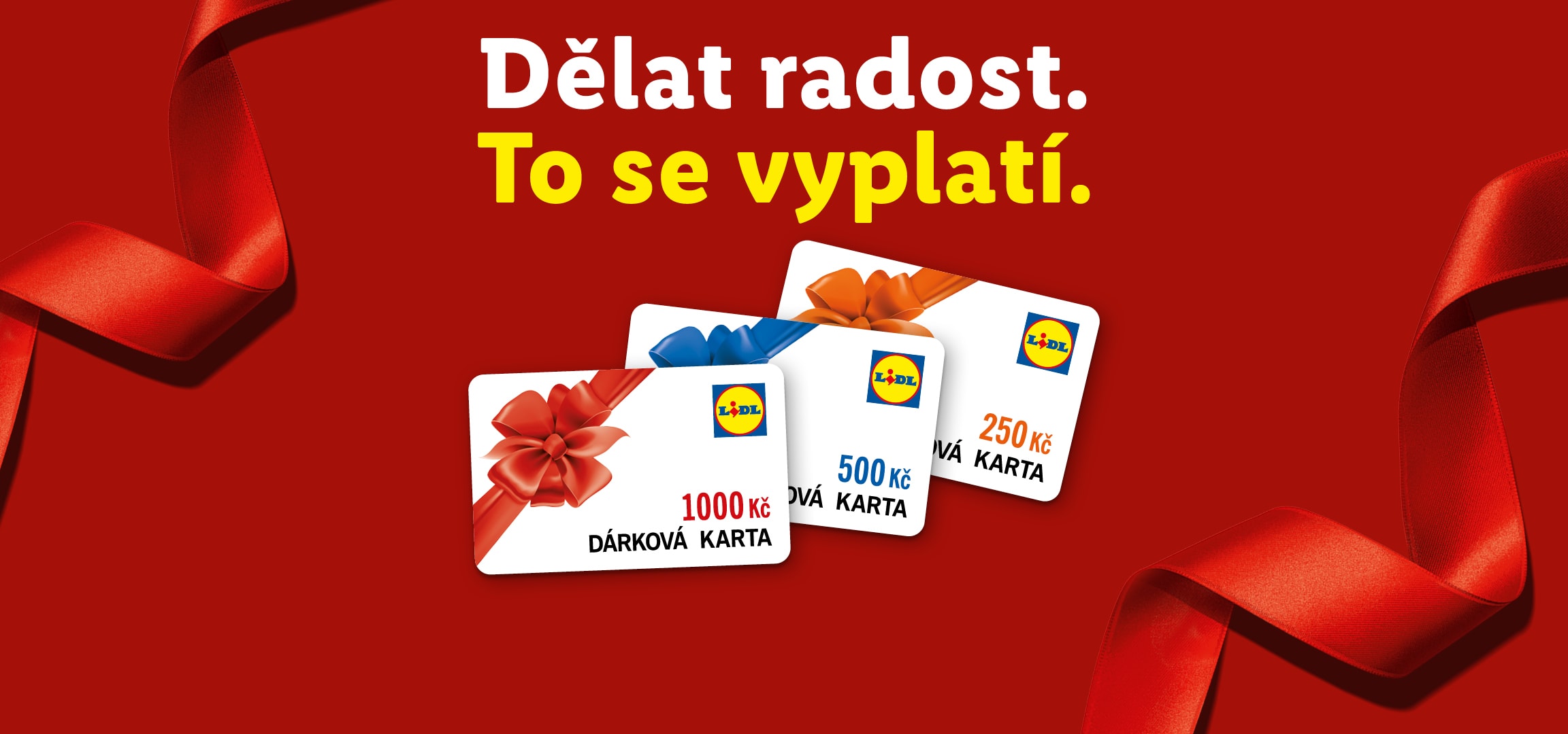 Dárkové karty Lidl v hodnotách 250, 500 a 1000 Kč s červenou stuhou na červeném pozadí.