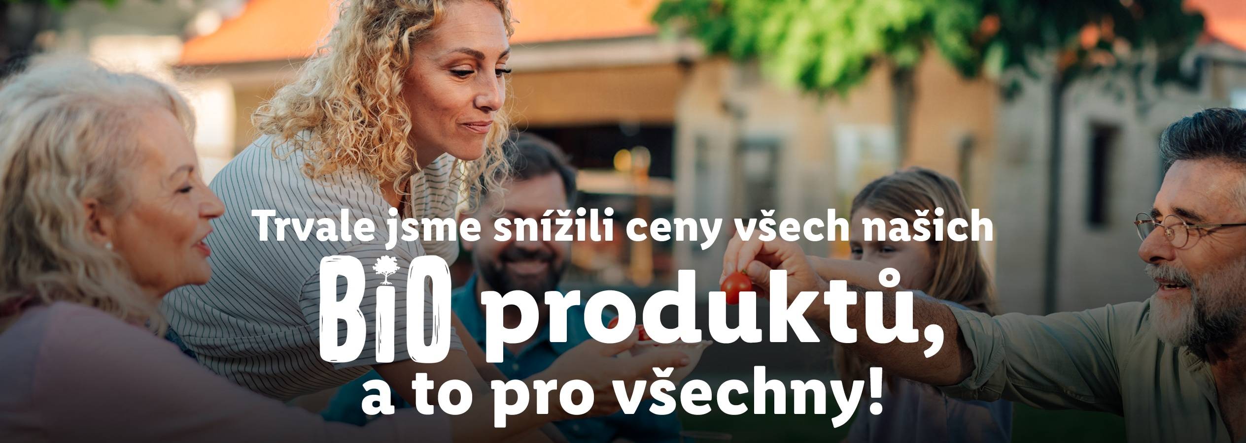 Rodina si užívá venku, s textem: 'Trvale jsme snížili ceny všech našich BIO produktů, a to pro všechny!'