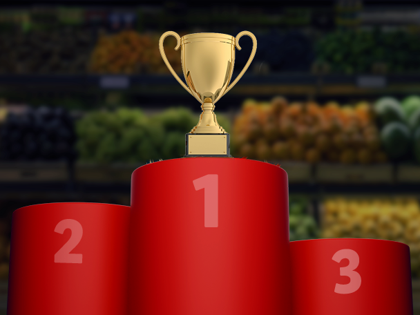Zlatá trofej na červeném pódiu s čísly 1, 2 a 3.
