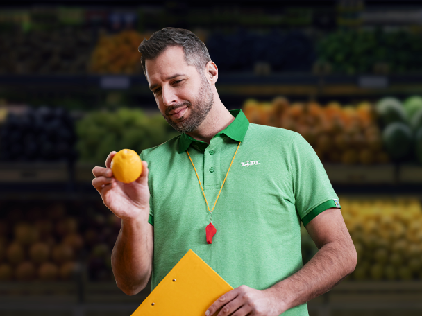 Zaměstnanec Lidlu kontroluje citrony v supermarketu.