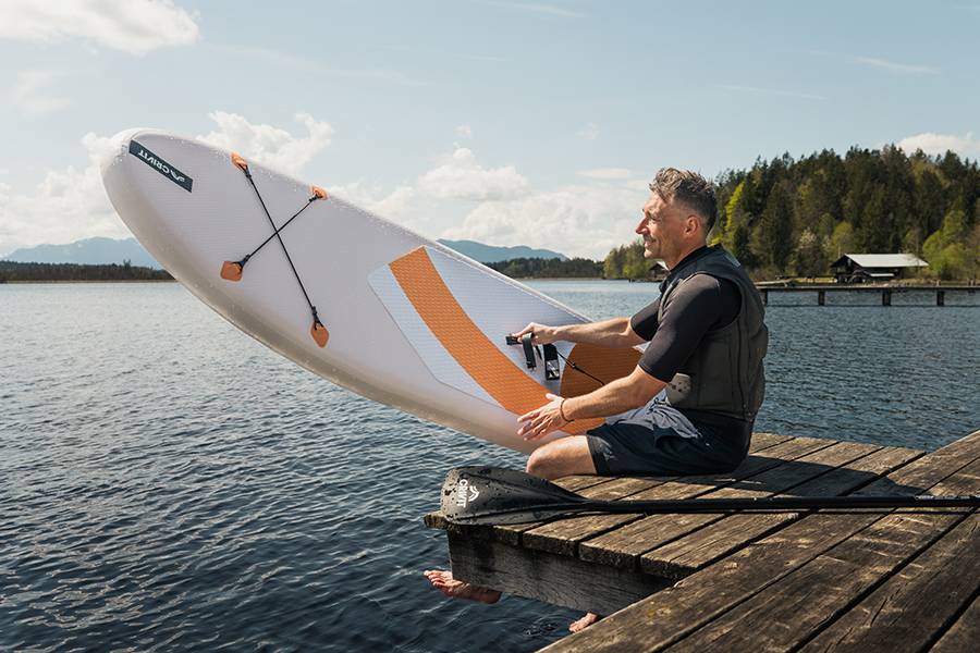 Aquamarina paddleboard a pádlo u jezera.