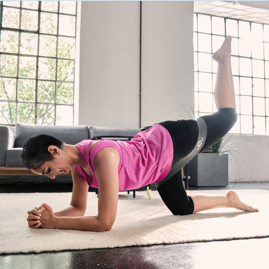 Žena cvičí nohy s odporovým páskem Senfit.