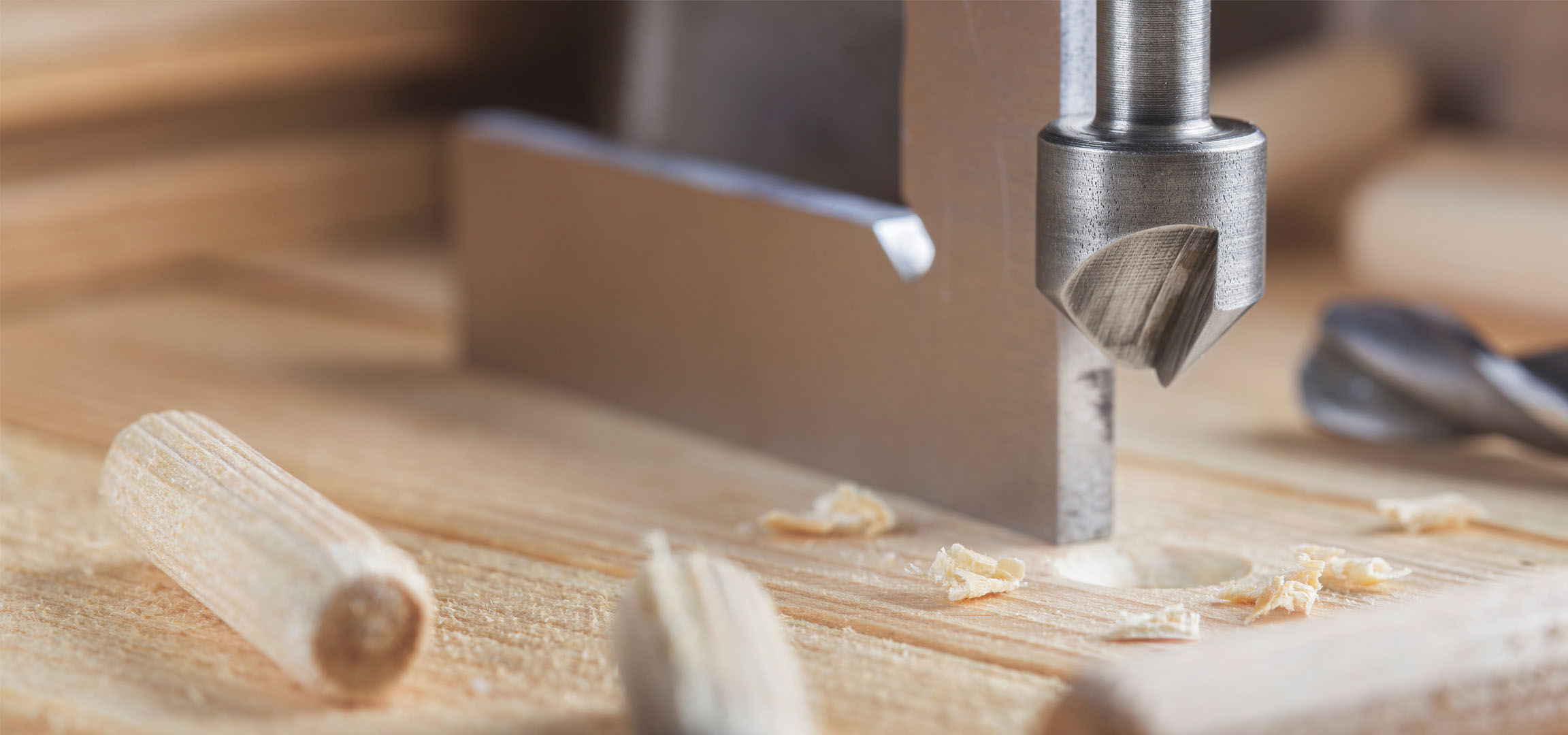 Dřevěné kolíky, vrták a dřevo během stavby.