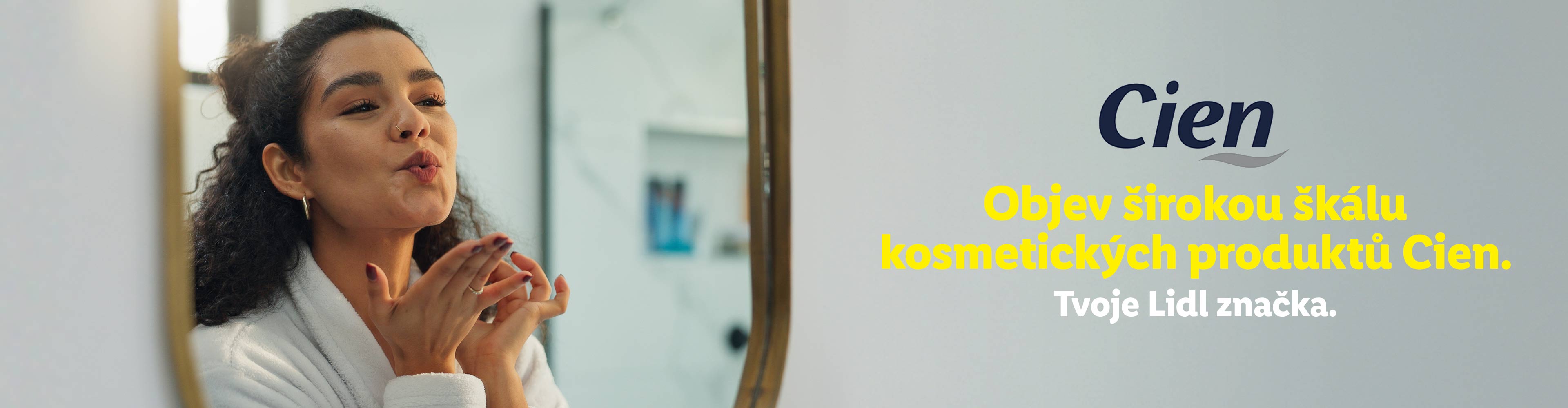 Žena v županu se líbá do zrcadla, text: Hýčkejte se od hlavy až k patě.