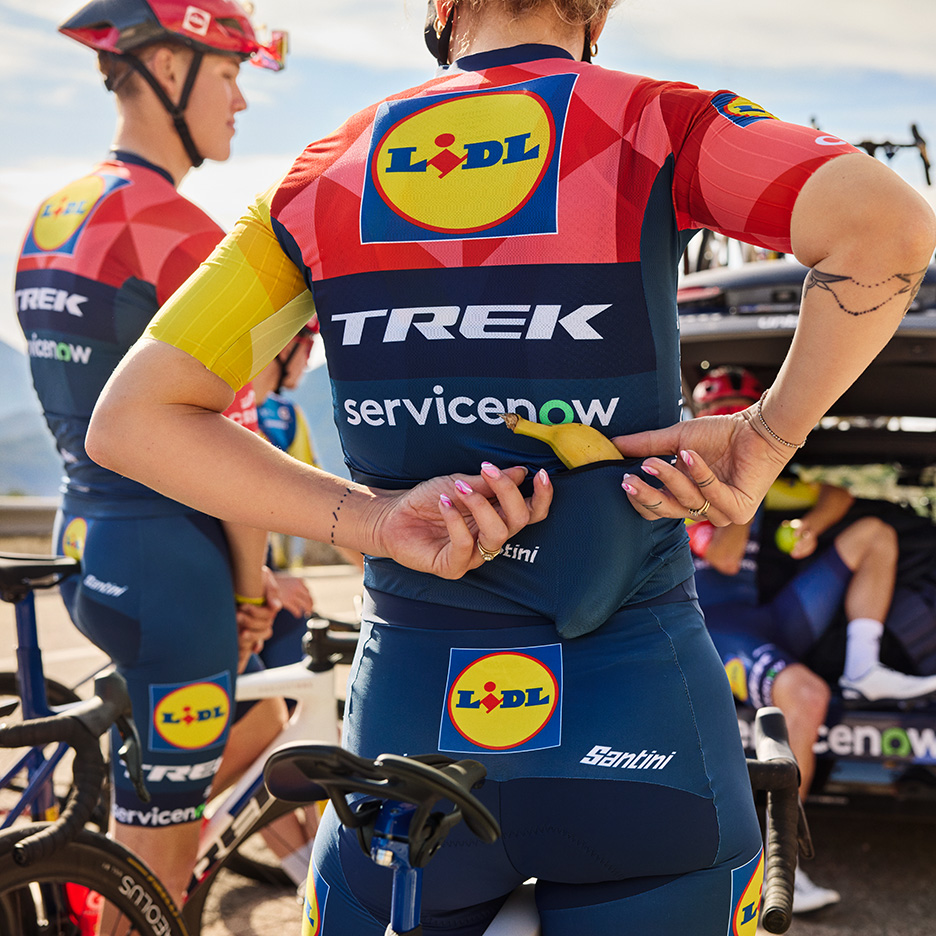 Cyklisté ve sportovním oblečení s banánem v kapse, připravující se na závod.