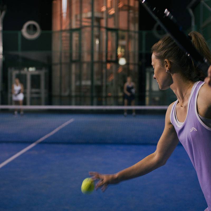 Padel tenis: hráčka s raketou, míčky