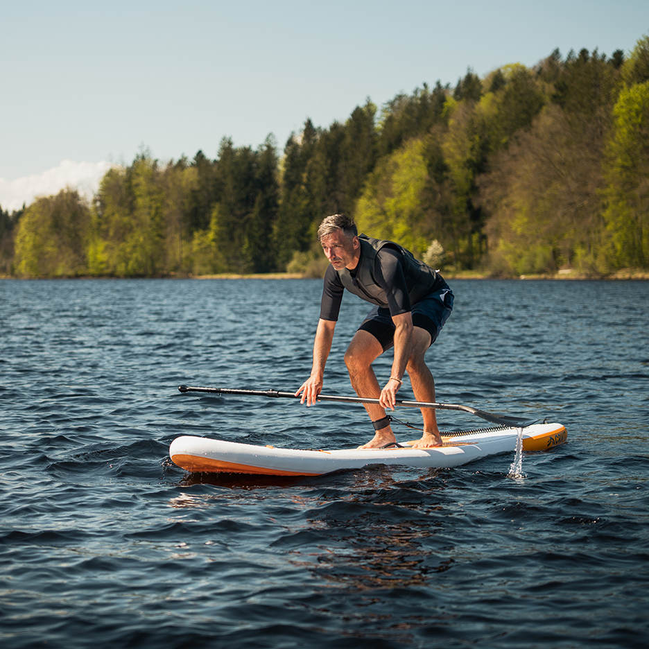 Muž paddleboarduje na jezeře.