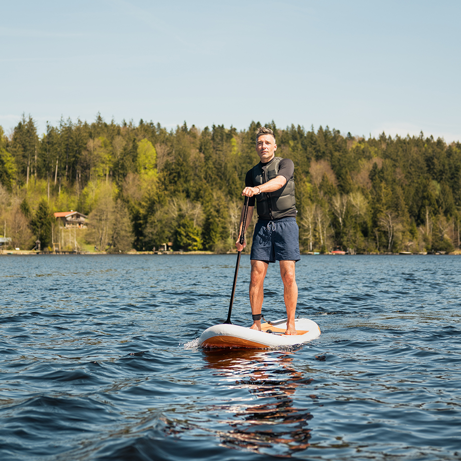 Muž na paddleboardu na jezeře.