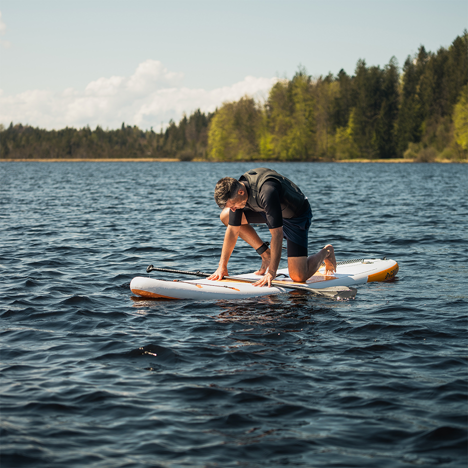 Muž na paddleboardu na jezeře.