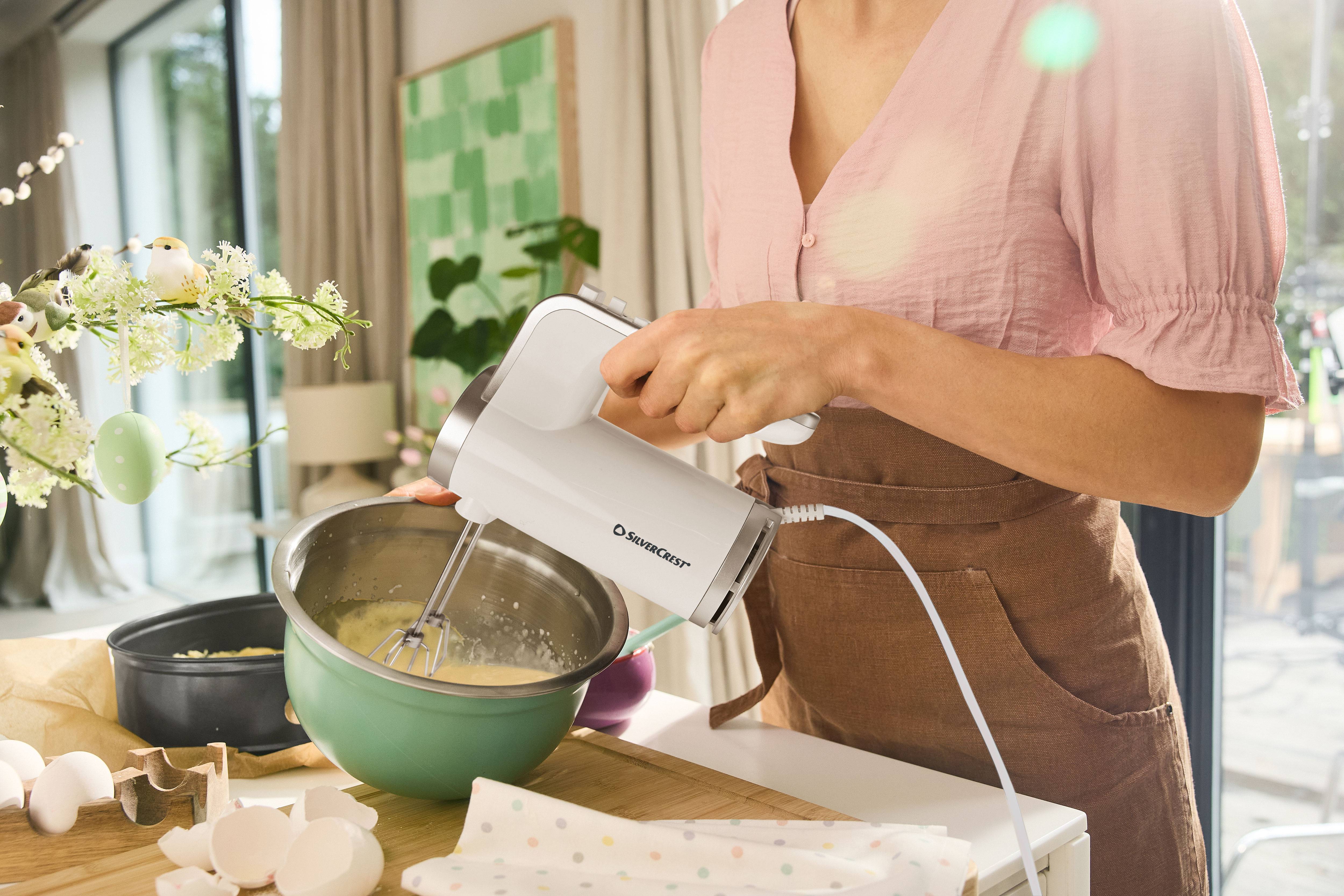 Žena používá ruční mixér SilverCrest k míchání ingrediencí v míse.