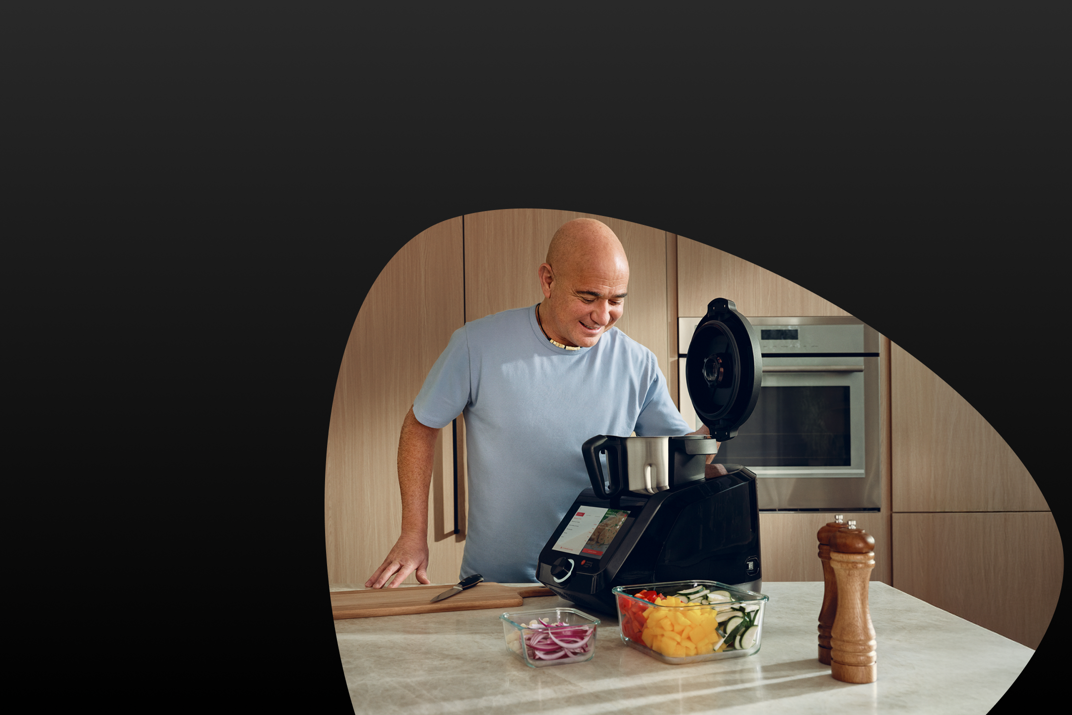 Andre Agassi připravuje zeleninu v kuchyňském robotu.