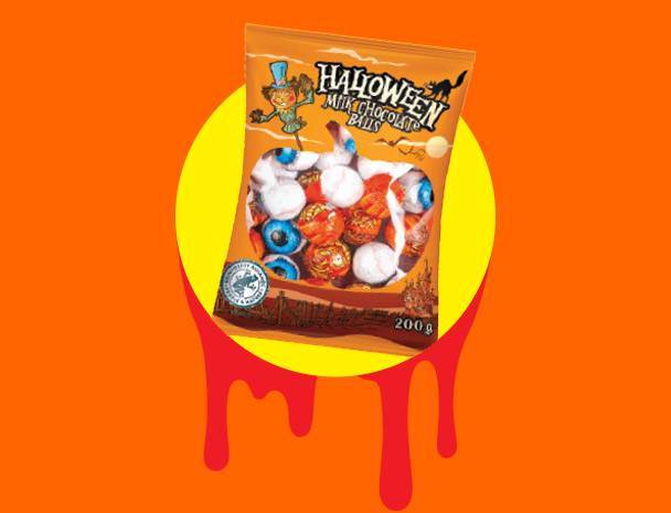 Balíček halloweenských mléčných čokoládových kuliček ve tvaru očí na oranžovém pozadí.