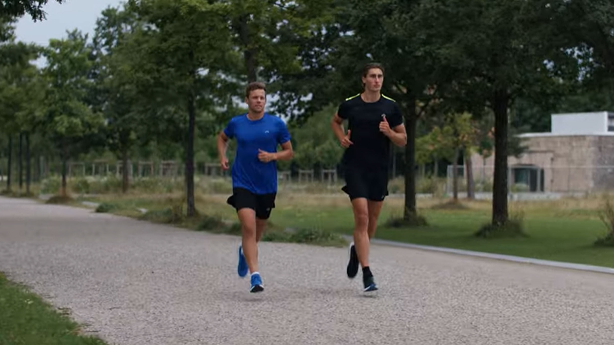 Dva muži běží ve sportovních tričkách a šortkách