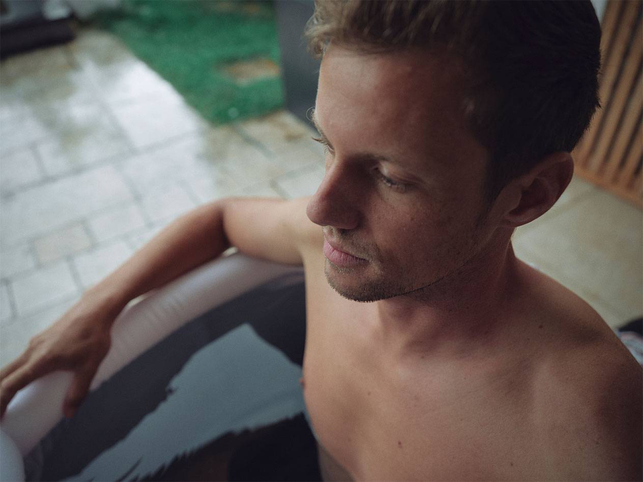 Muž relaxující ve venkovní nafukovací vířivce.