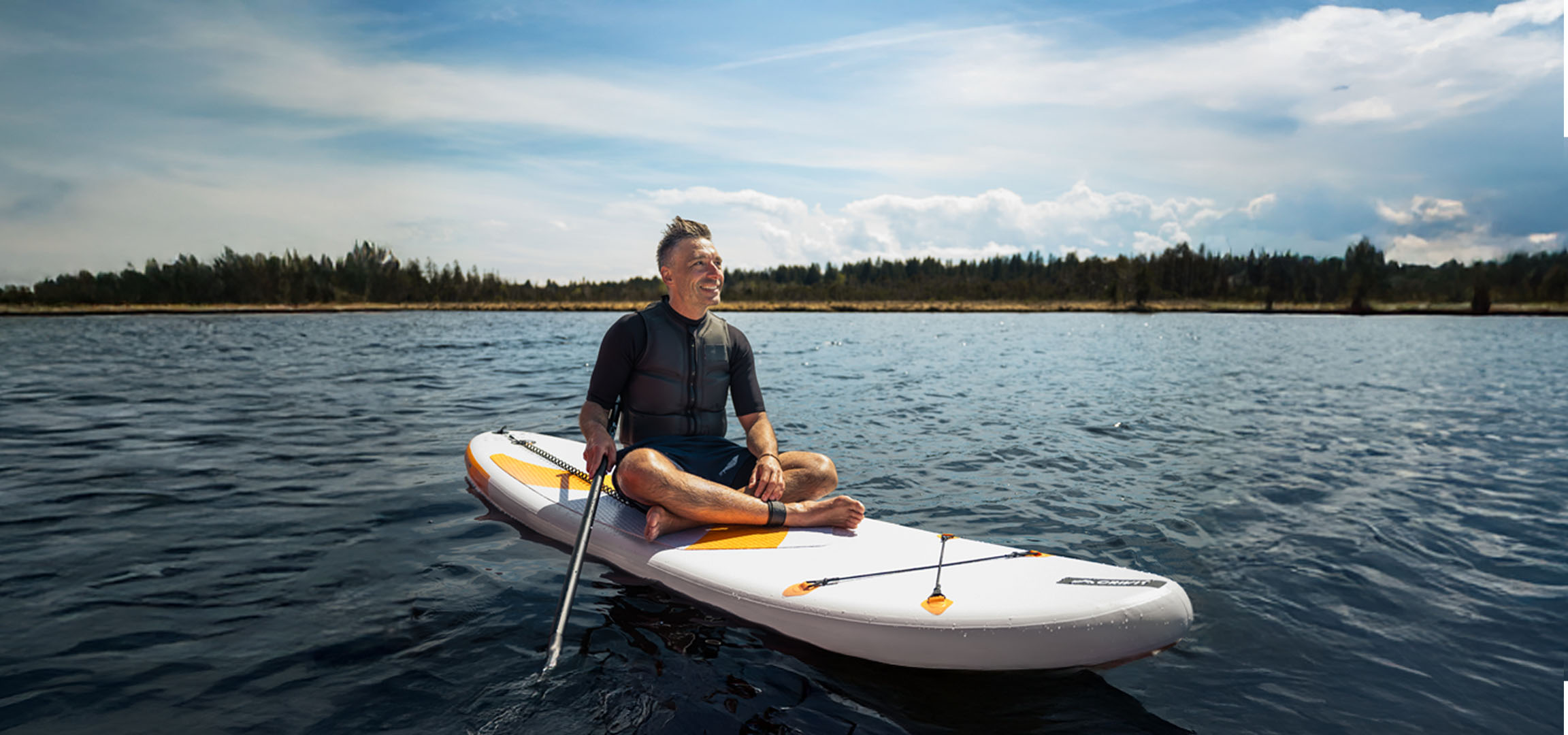 Muž na paddleboardu na jezeře.