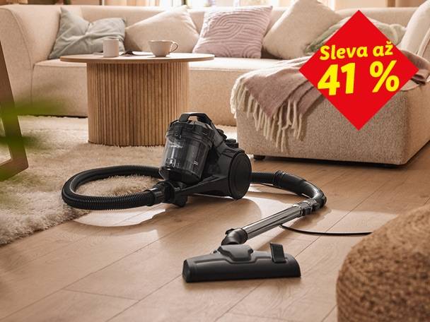 Černý vysavač na dřevěné podlaze a koberci v obývacím pokoji. Sleva až 41 %.