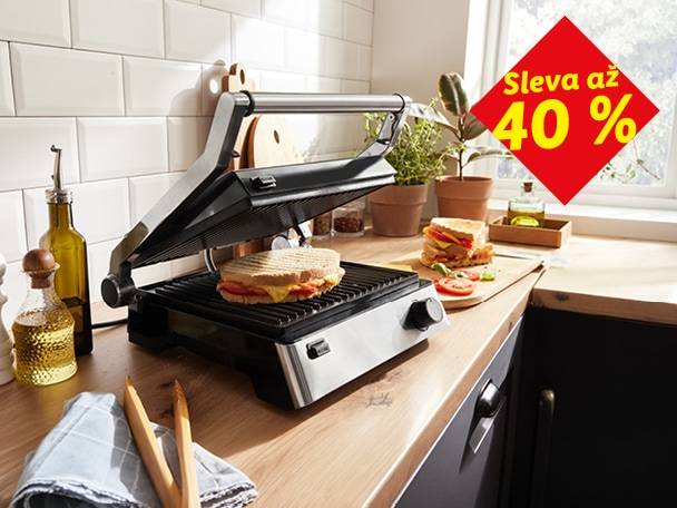 Sendvičovač s připraveným sendvičem na kuchyňské lince, s nápisem 'Sleva až 40 %'.