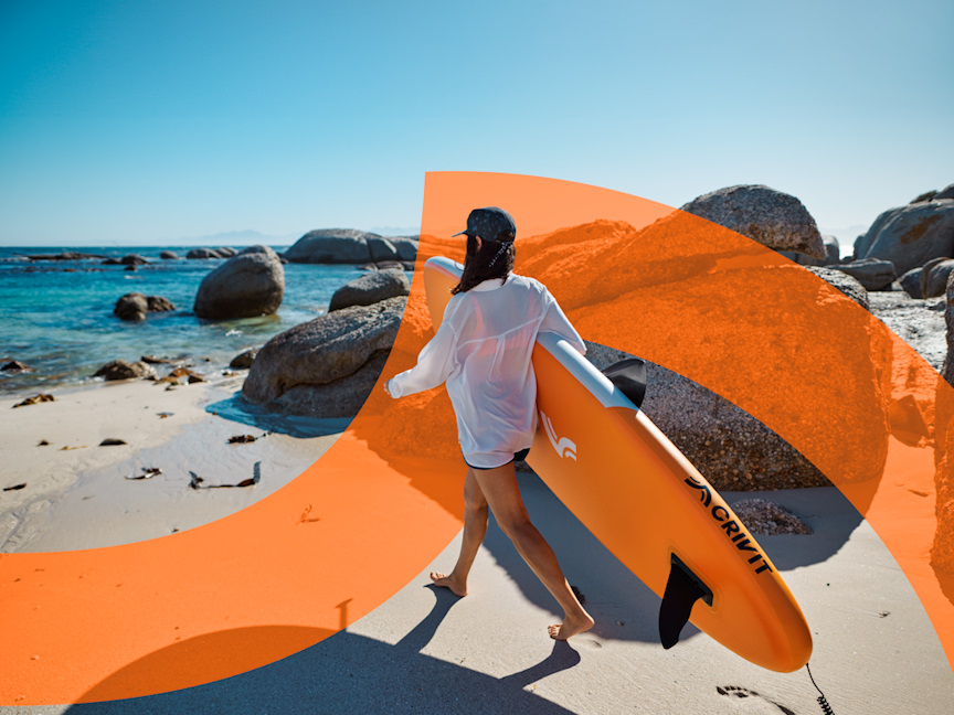 Žena na pláži s paddleboardem, jde směrem do moře