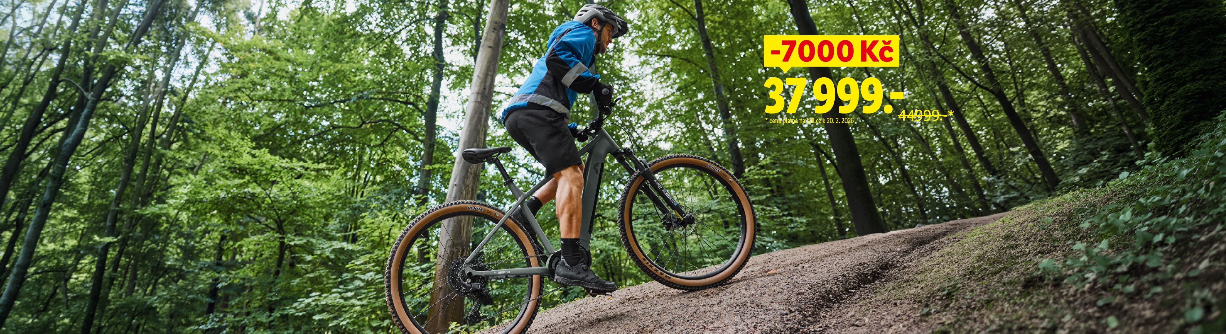 Muž na horském kole v lese, s cenou 37 999 Kč a slevou 7 000 Kč.