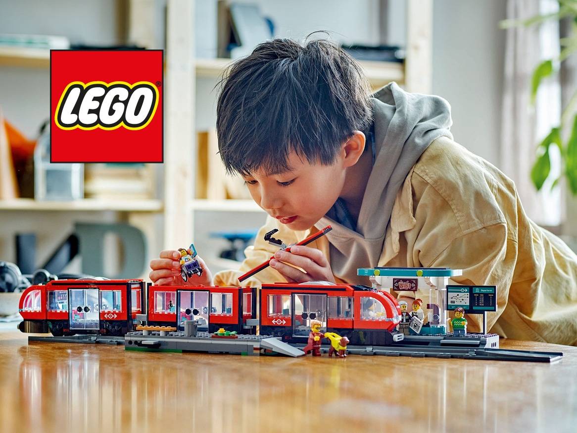 Chlapec si hraje s červeným vláčkem a nástupištěm z kostek.